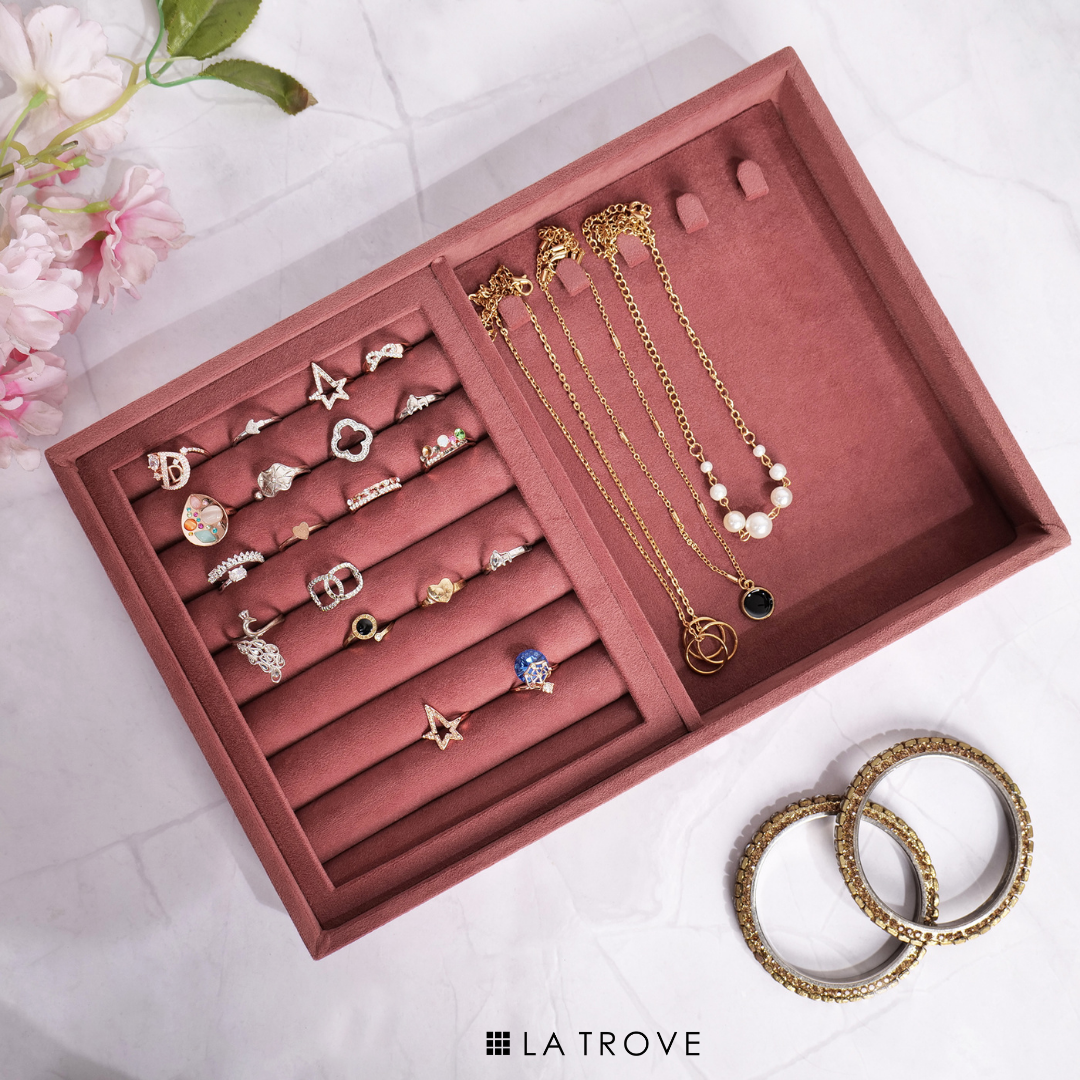 Dark pink organizer tray with velvet lining for rings and chains.