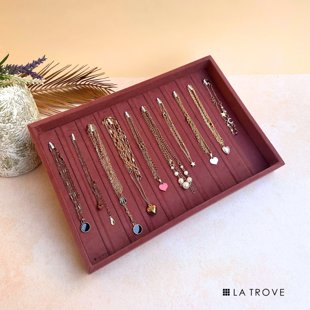 Dark pink velvet tray for organizing bracelets, chains, and bangles.