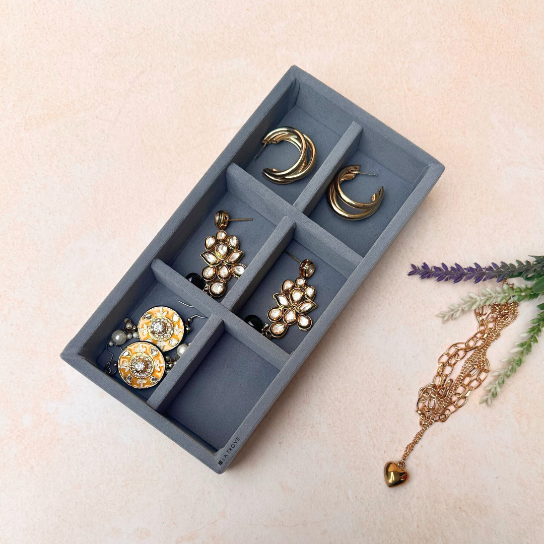 Grey 6-compartment jewelry storage tray for rings, earrings, and pendants.