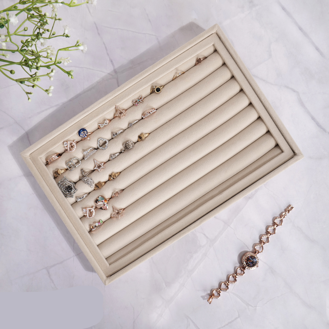 Cream velvet tray for displaying and storing rings and cufflinks.