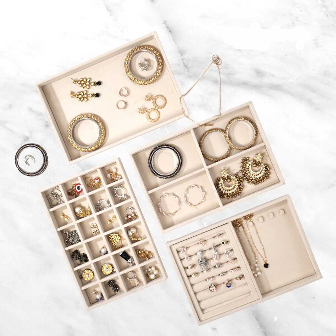 Cream velvet stackable jewellery tray set of 4 with assorted grids for rings, earrings, and necklaces.