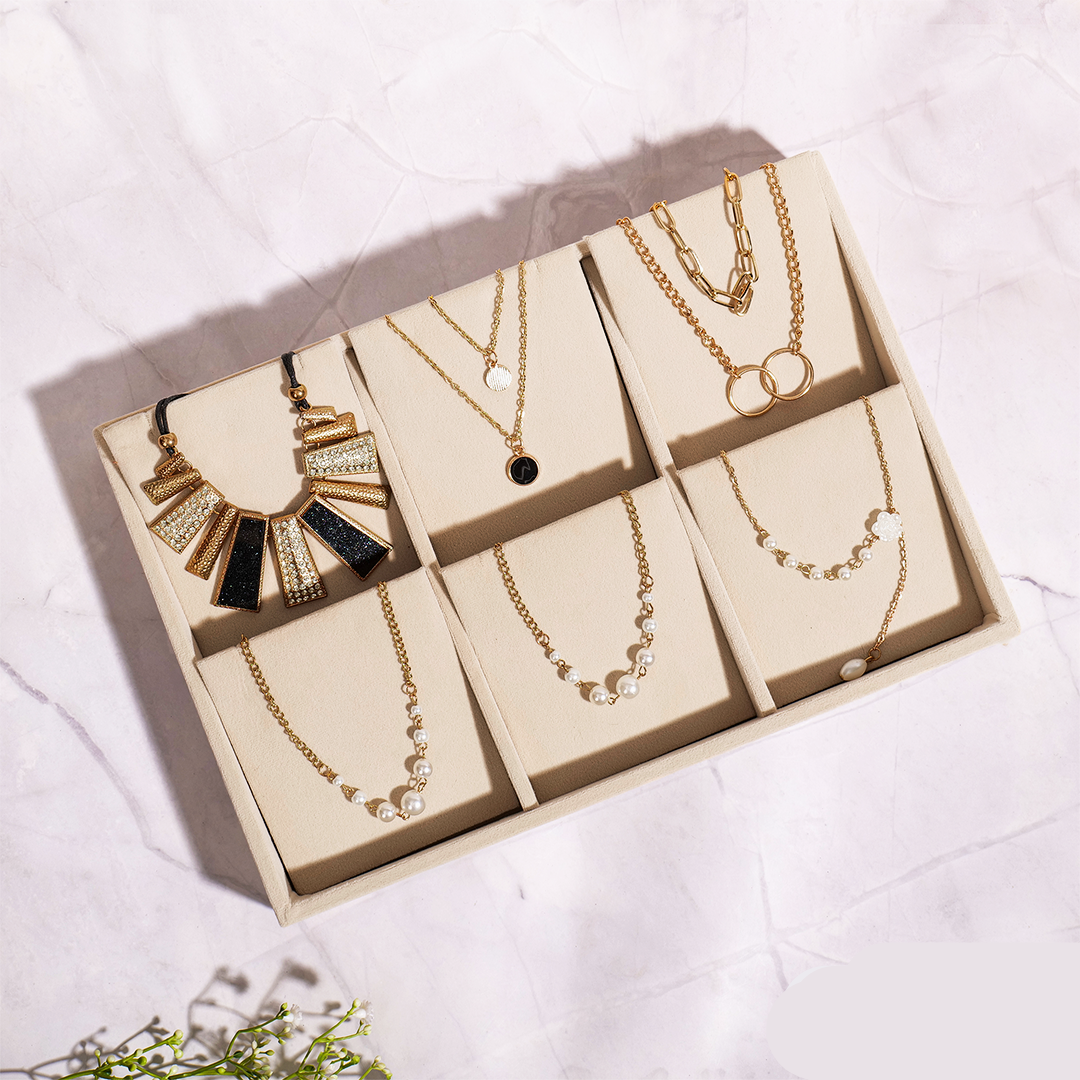 Cream velvet necklace organiser tray for layered chains and pendants.