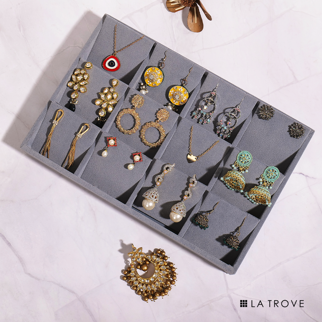 Grey organiser tray for displaying earrings with soft velvet lining.