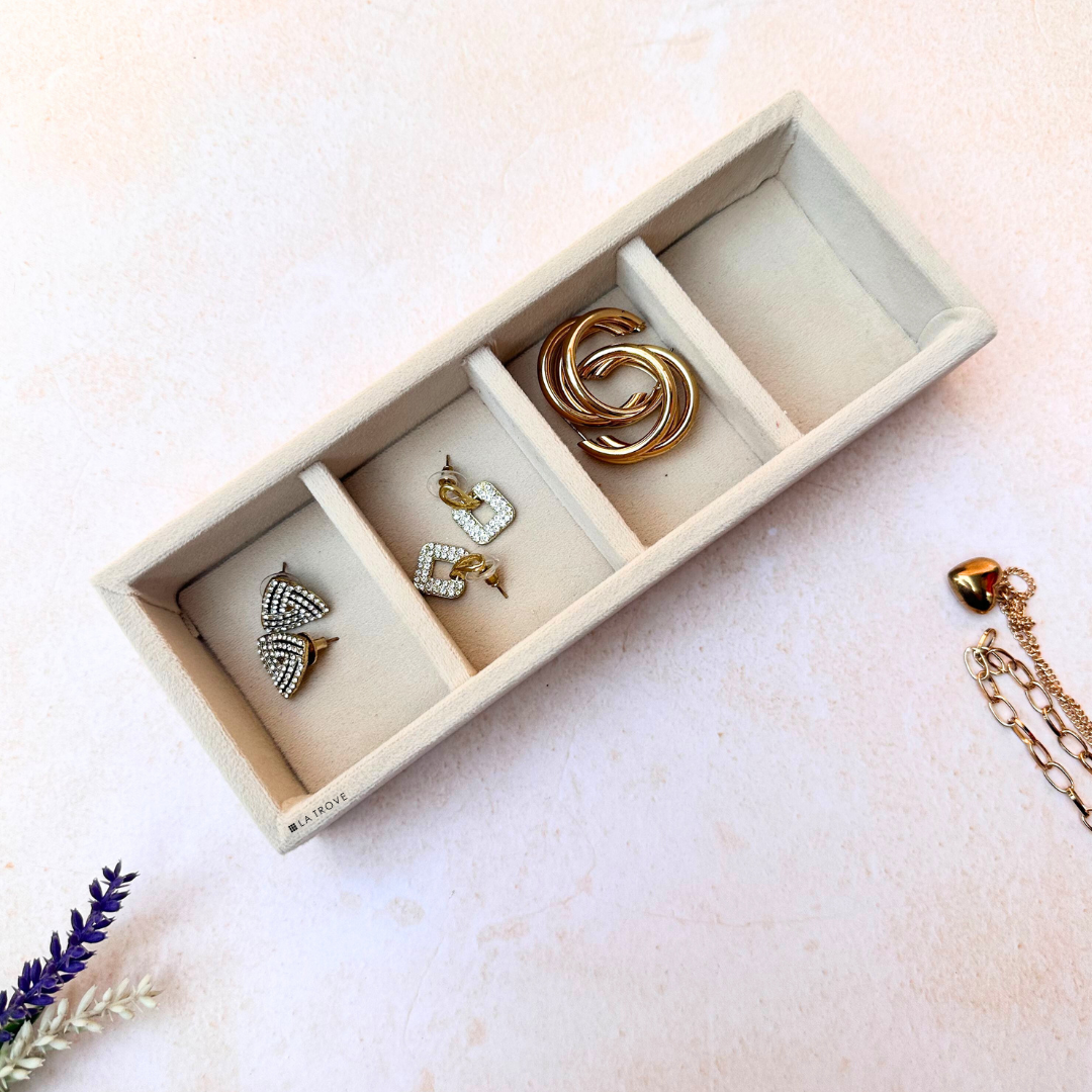 La Trove 4-Grid Jewellery Tray in cream velvet holding gold and silver earrings.