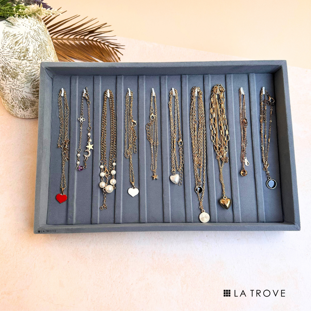 Grey bracelet and chain organiser tray with soft velvet surface.
