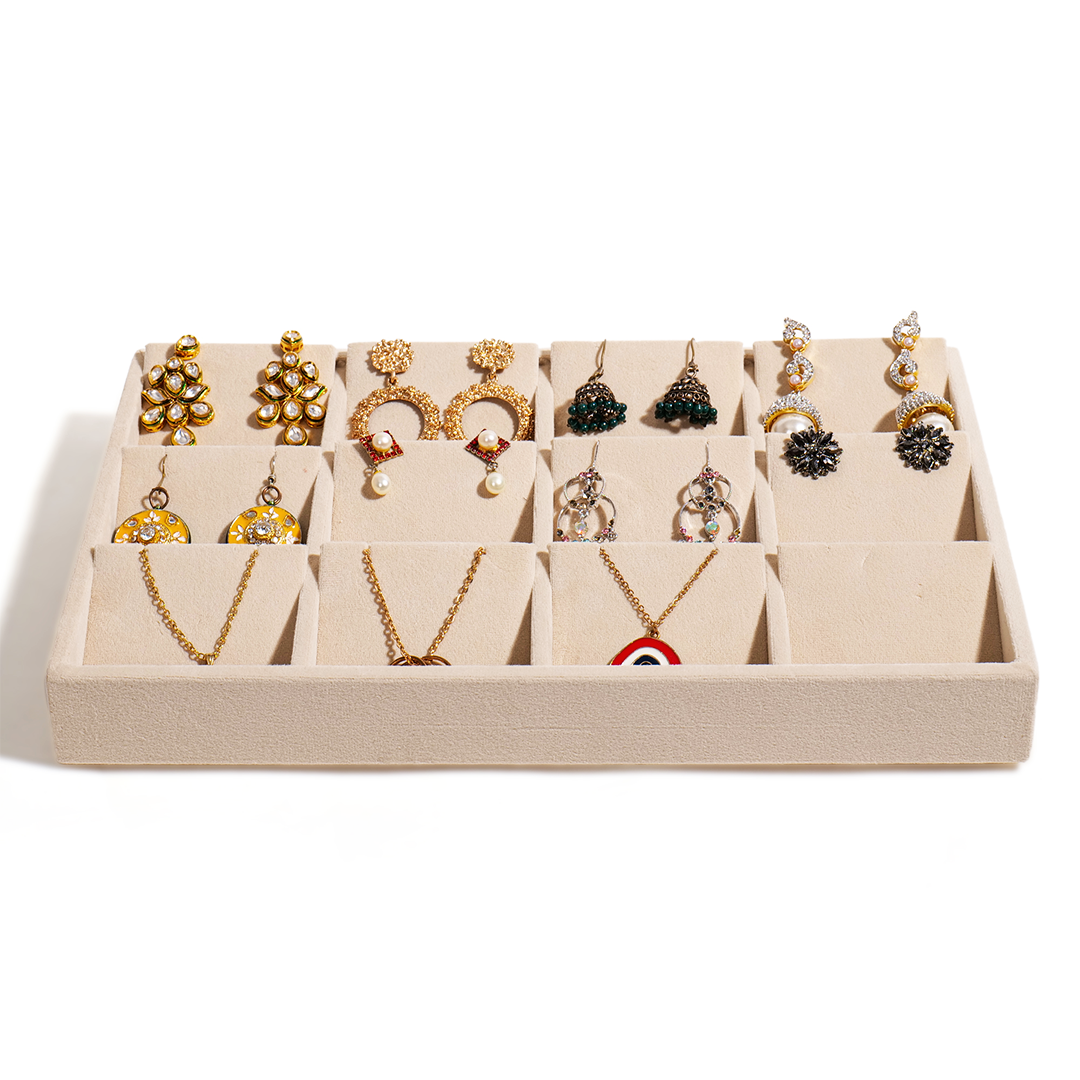 Cream display jewellery tray for necklaces, bangles, and earrings.