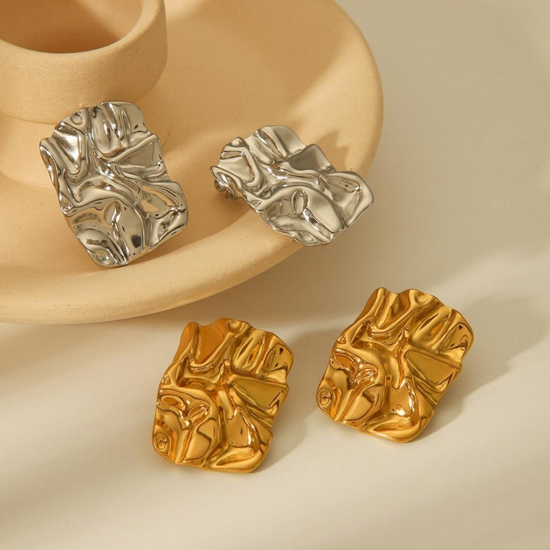 Sculpted gold textured statement earrings close-up view.