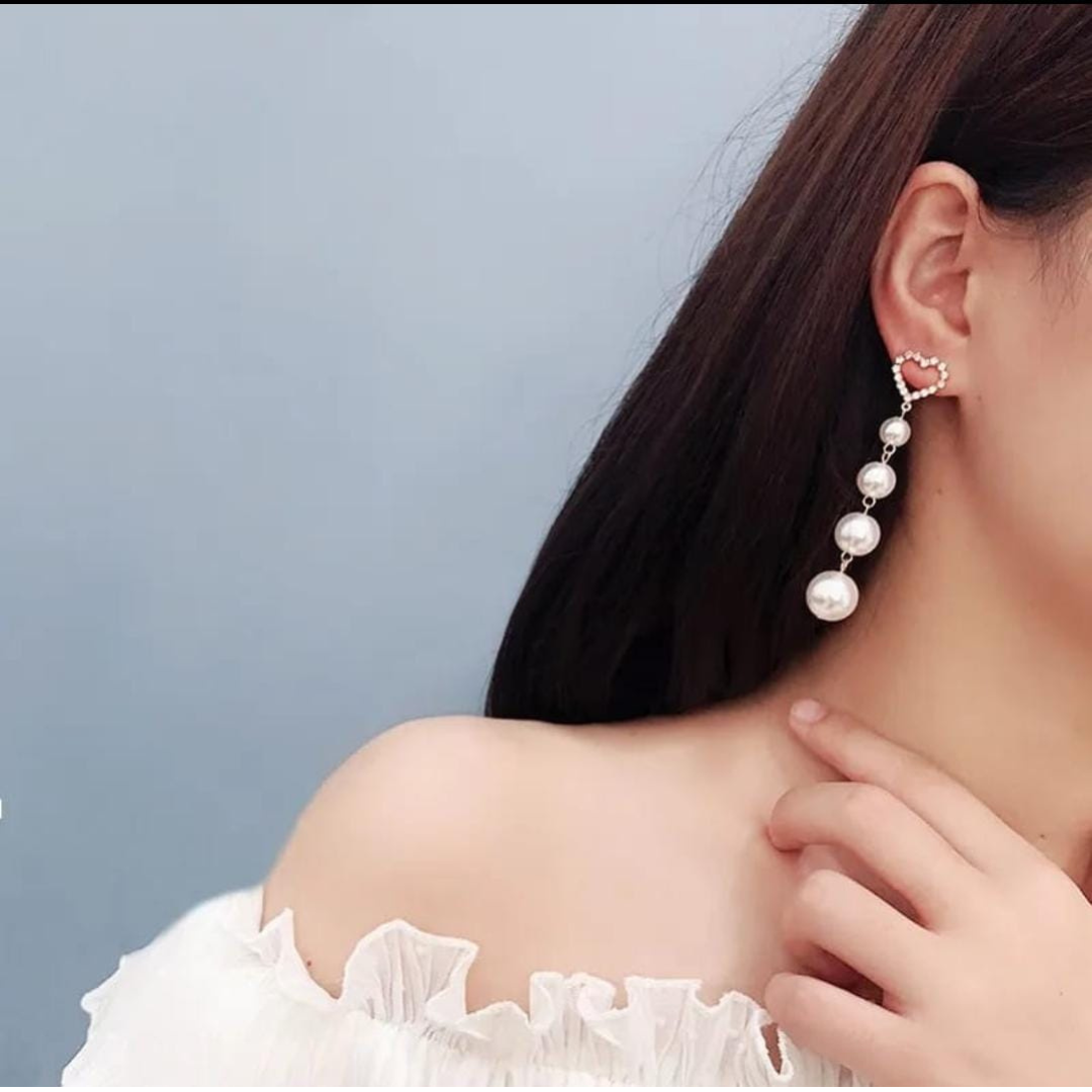Elegant Design: Heart studs paired with graceful pearl danglers.