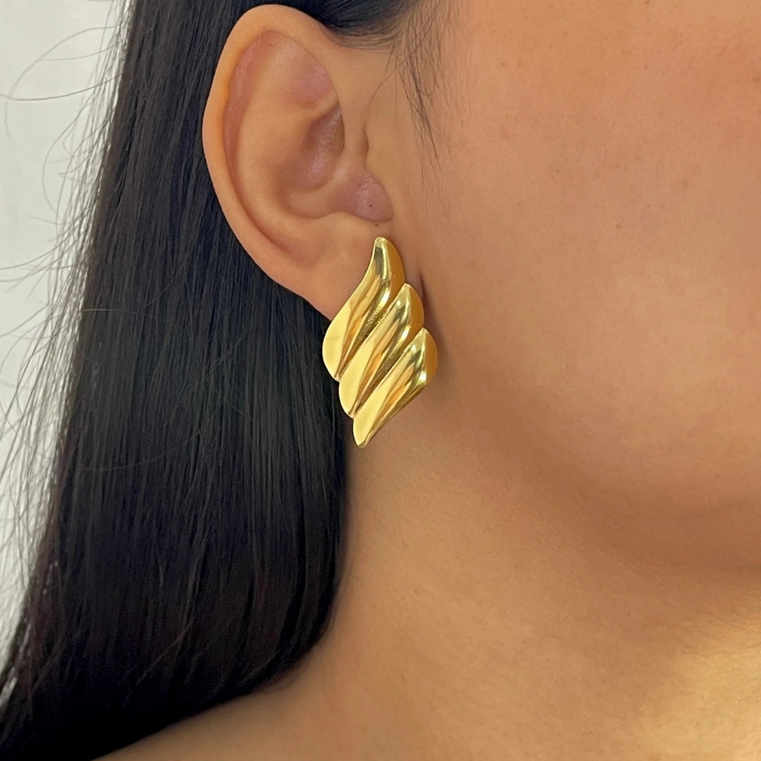 Designer gold earrings with wave pattern for women.