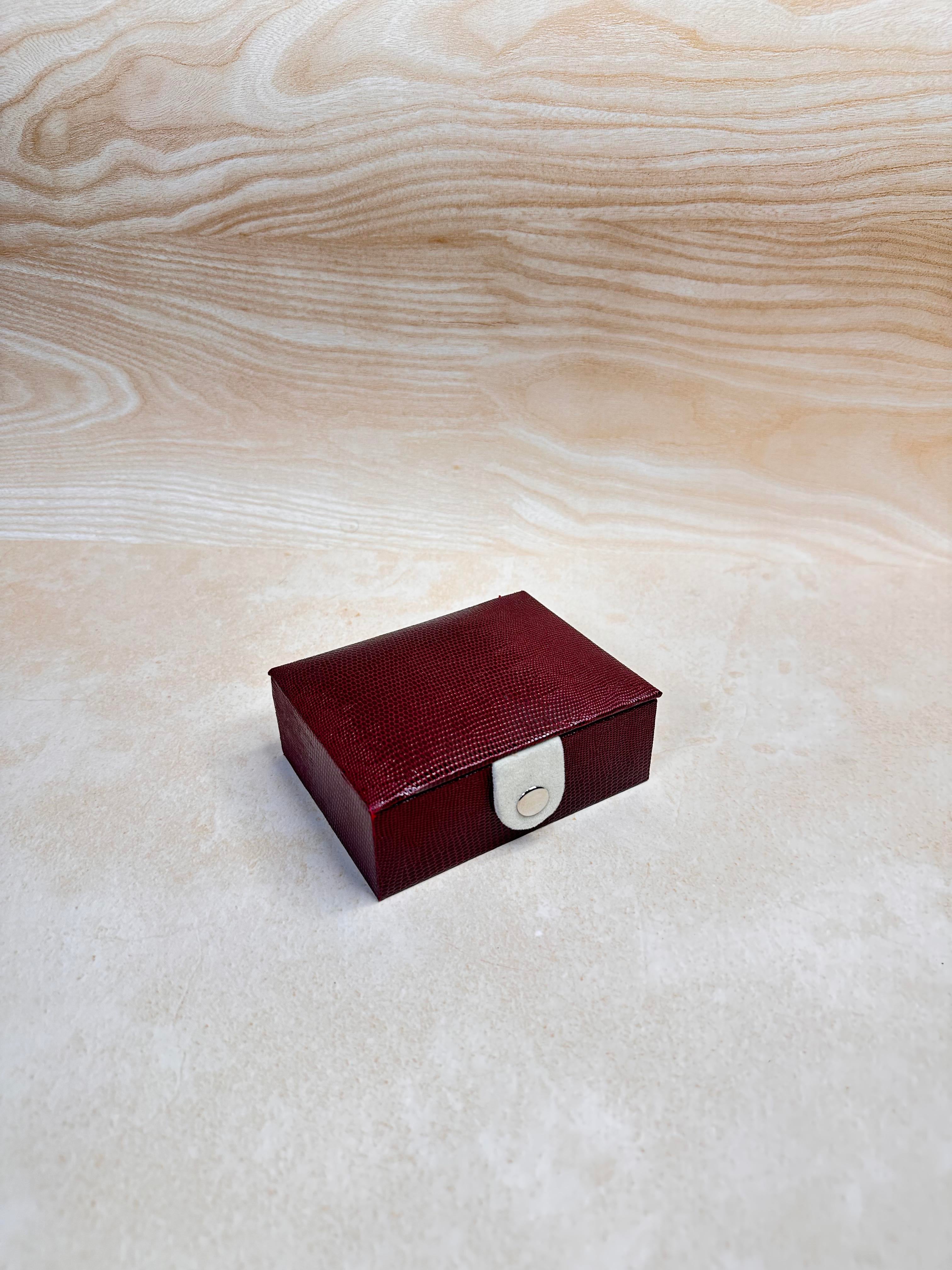 Maroon jewellery organiser tray with slots for rings and earrings.